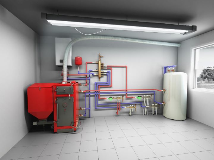 Modern pellet boiler with pipes and hot water storage tank in tiled room